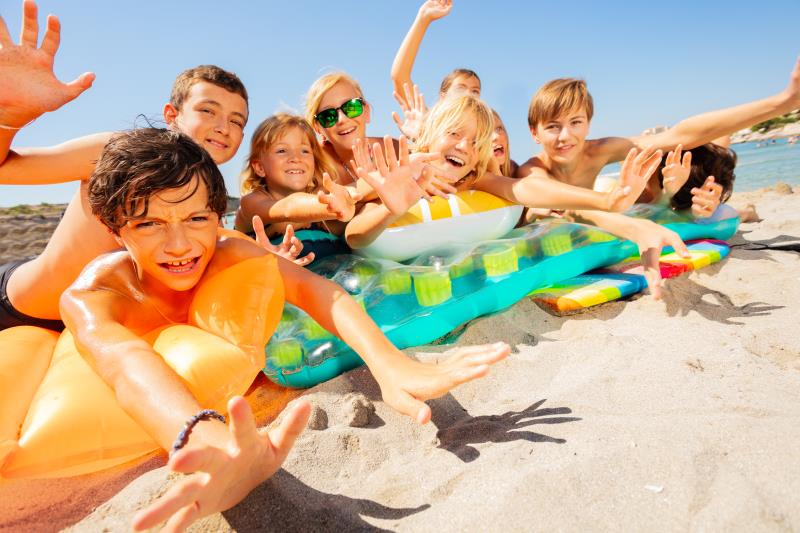 Kinder spielen am Strand in den Sommerferien