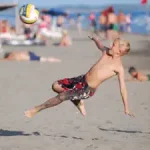 junge-spielt-am-strand-fussball-und-lernt-dabei-englisch