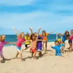 viele-glueckliche-kinder-am-strand-beim-spanisch-lernen