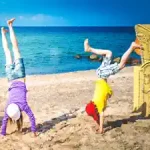 zwei-kinder-am-strand-mit-handstand-im-spanisch-urlaub