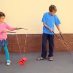 zwei-kinder-lernen-mit-den-diabolo-kunsstuecke-im-zirkus