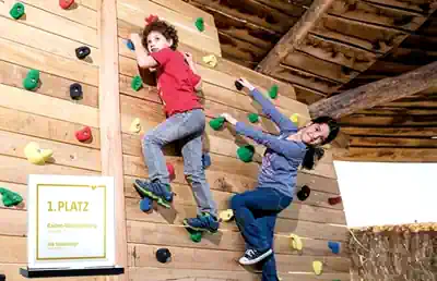 zwei-jungen-klettern-an-der-boulderwand-vom-zertifizierten-reiterhof