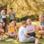 eine-gruppe-von-schueler-lernt-im-park-bei-sonnenschein-englisch