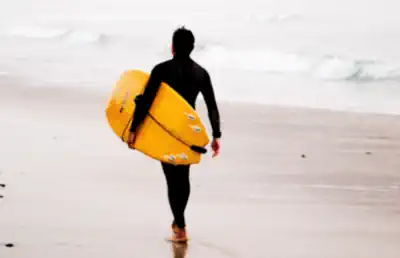 ein-jugendlicher-geht-zum-strand-zum-ostern-surfen